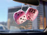 Puffy dice hanging from rear view mirror.