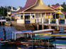 Boats on pier with traditional architecture behind.