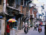 Street scene with food hawker and motorbikes.