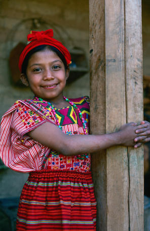 A young girl hugging a pole in the street