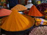 Mounds of spice powders are displayed by a vendor at New Market.