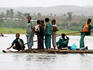 Boy poles his schoolfriends across Blue Nile on papyrus canoe.