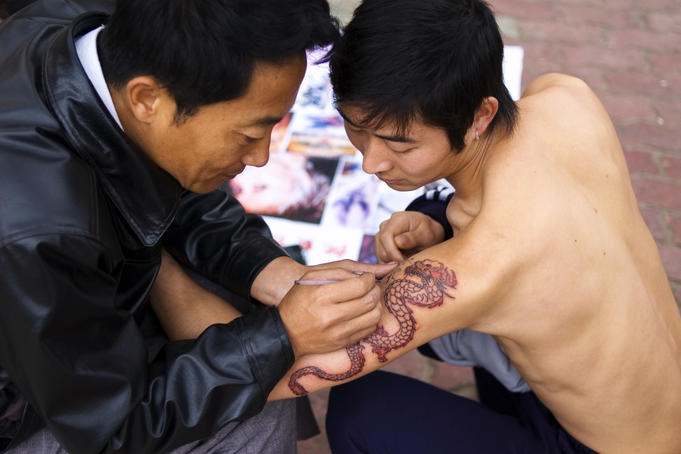 Updating tattoo on streets of Jinghong.