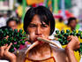 Taoist spirit medium in trance with large objects pierced though both cheeks, Vegetarian Festival.