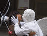 'Statue' of Cupid embracing tourist outside Uffitzi Gallery.