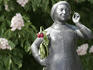 Statue with wilting red rose in Viktualienmarkt beer garden.