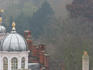 Misty rooftop view with domes at dusk.