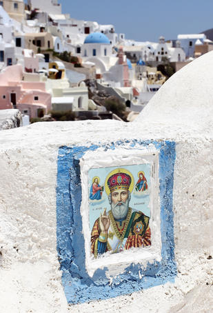 Religious art on balcony overlooking houses.