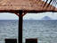 Deckchairs on beach under umbrella.