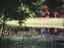 Miniature wooden house on pond, traditional house in background, Aland Islands.