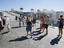Tourists photographing pelican, Mykonos, Cyclades Islands.
