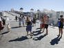 Tourists photographing pelican, Mykonos, Cyclades Islands.
