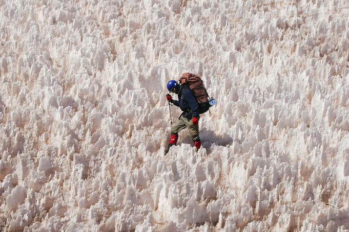 Overhead of mountaineer negotiating snow pinnacles ('penitientes') below La Ramada peak, Rio Colorado headwaters.
