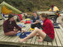 Bushwalkers relaxing, playing cards, on remote area camping platform, Western Arthur Range.