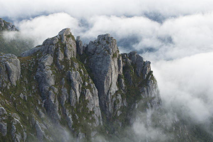 Crags rise above valley-filling cloud at dawn, Western Arthur Range.