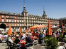 Open-air cafes on Plaza Mayor with Real Casa de la Panaderia in background.