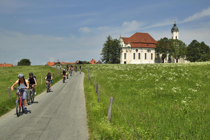 Children cycling past the Pilgramage Church of the Scourged Saviour.