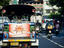 Tuk-tuk and motorcycles on city street.