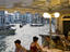 Alfresco diners on bank of Grand Canal near Rialto Bridge.