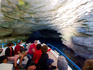 Travellers entering grotto on boat.