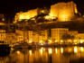 Port and old town walls at night.