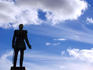 Statue in Senaatintori silhouetted against blue sky.