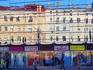 Glass-fronted shops with reflection of old buildings.