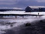 Tourists on beach in front of derelict aircraft hangar, Whalers Bay.