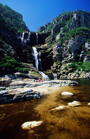 Hikers resting near waterfall.