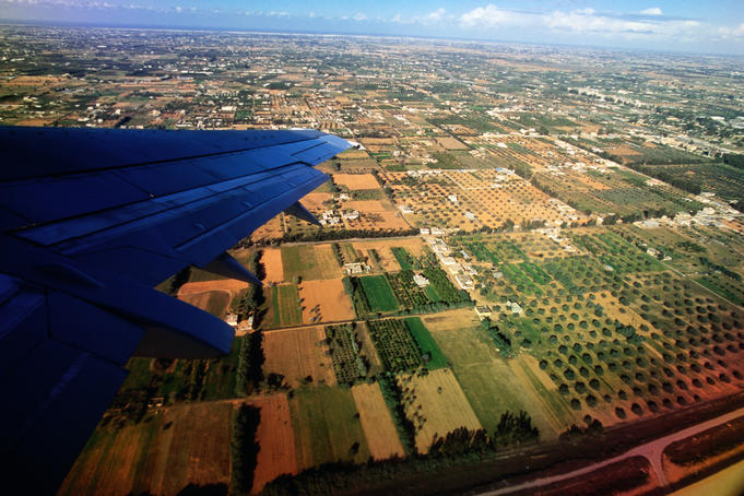 Aerial view of the south of the city and the wing of an aeroplane.