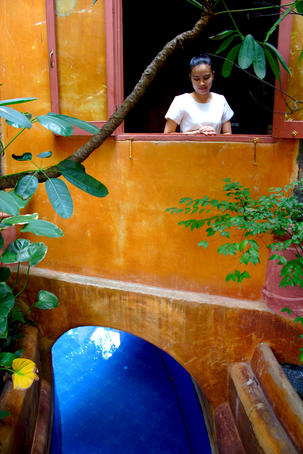 Thai woman standing in window of Baan Thai Spa and Wellness Retreat.