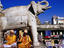 Sadhus sitting below carved elephant at entrance to Jagdish Temple.