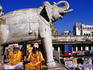 Sadhus sitting below carved elephant at entrance to Jagdish Temple.