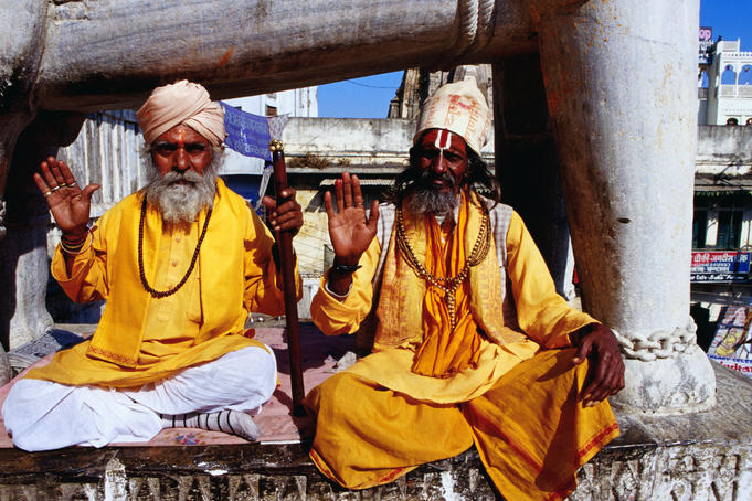 Sadhus sitting below carved elephant at entrance to Jagdish Temple.
