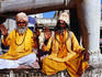 Sadhus sitting below carved elephant at entrance to Jagdish Temple.