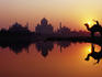 Taj Mahal & silhouetted camel & reflection in Yamuna River at sunset.