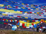 Pilgrim stringing up prayer flags with mountains in background.