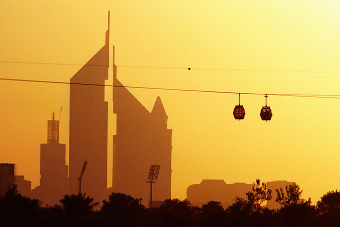Creekside Park cable cars (gondolas) passing the Emirates Towers at sunset.