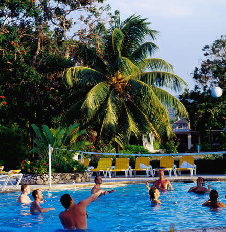 Group playing volleyball in swimming pool, Hotel Breezes.