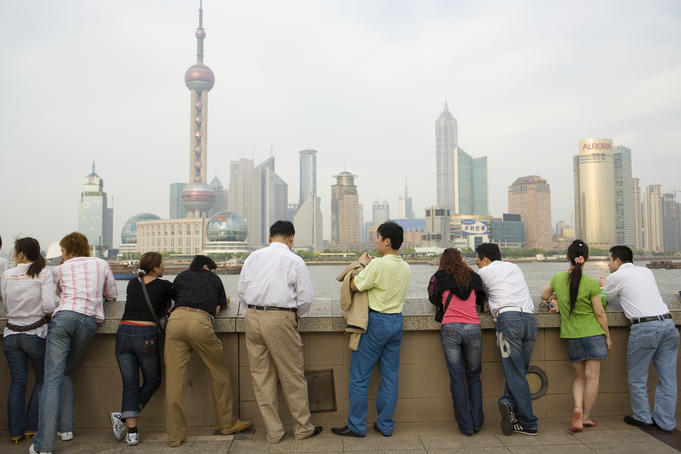 People looking across Huangpu river towards Pudong from the Bund.