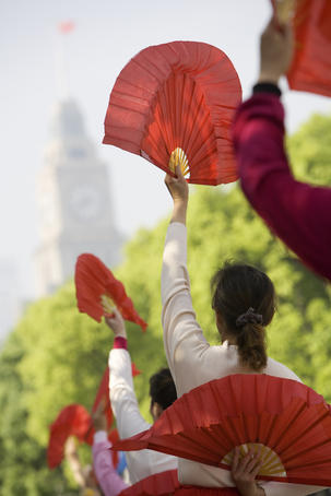 Women practising tai chi with fans on the Bund.