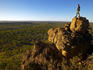 Man looking over savannah country from rocky outcrop.