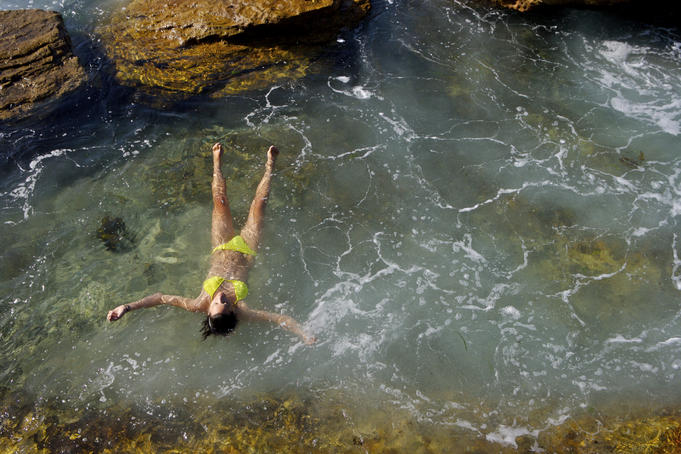 Woman floating in rock pool.