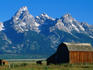 Wooden Mormon Row barn, built in the nineteenth century, and the Teton Range draped with snow - Grand Teton National Park, Wyoming