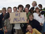 Children holding up 'Hi Mum' sign.