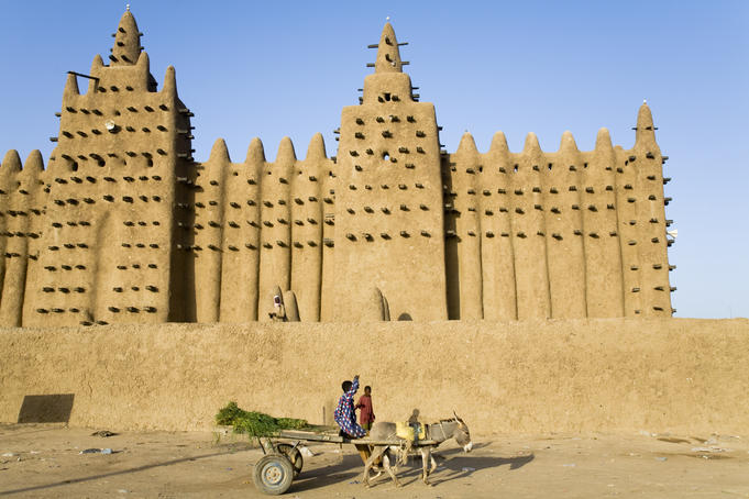 Young boy with donkey cart in front of the Grande Mosque du Djenne.