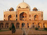 Woman wearing sari walking past Humayun's tomb in New Delhi.