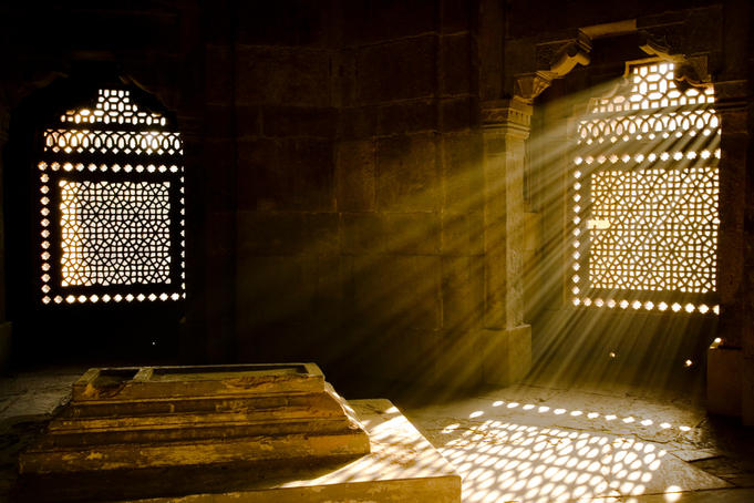 Shafts of early morning sunlight shining through lattice window into tomb of Isa Khan near Humayin's tomb in New Delhi.