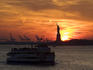 Statue of Liberty and Staten Island Ferry at sunset.