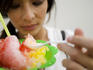 Young Pan-Asian woman eating ice cream.